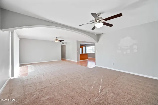 a view of a livingroom with a ceiling fan and window