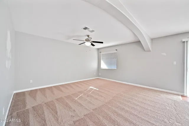 a view of an empty room with a chandelier fan
