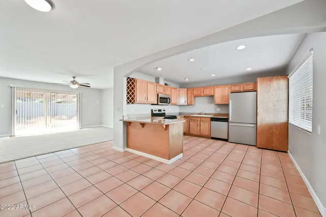 a large kitchen with stainless steel appliances granite countertop a large counter top a refrigerator and a sink