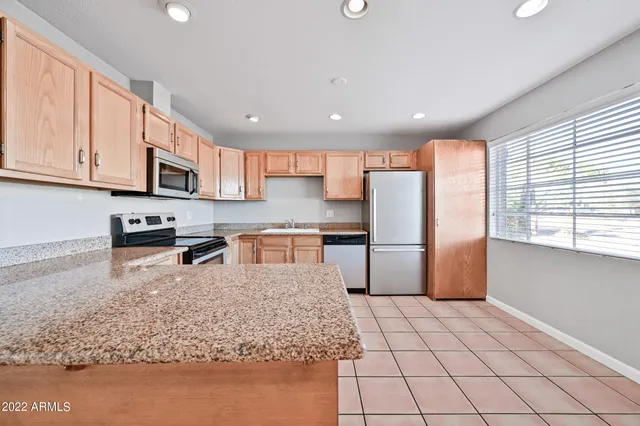 a kitchen with stainless steel appliances granite countertop a refrigerator sink and cabinets