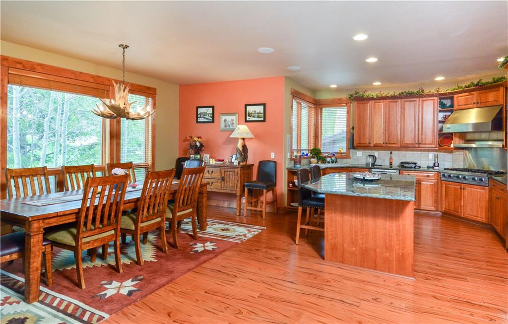 290 Elk Circle Keystone, CO 80435 - Photo 9 of 25 a dining hall with stainless steel appliances granite countertop a stove top oven a dining table and chairs with wooden floor