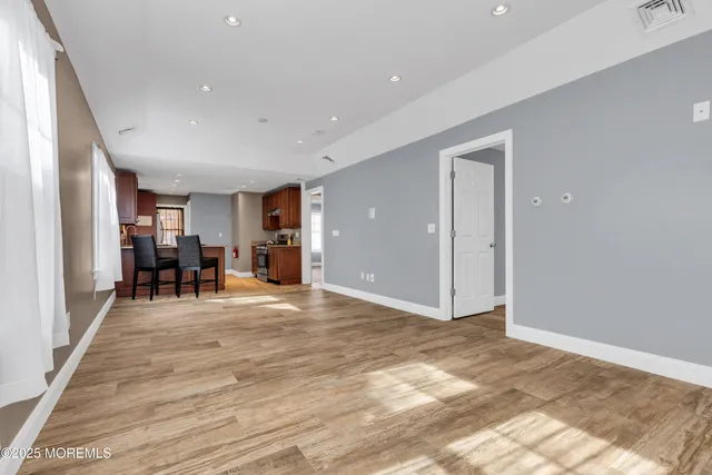 a kitchen with stainless steel appliances granite countertop a stove a sink dishwasher a dining table and chairs with wooden floor