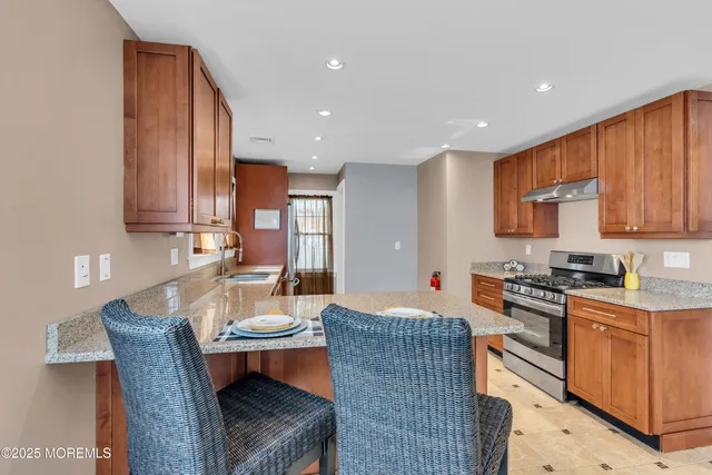 a kitchen with stainless steel appliances granite countertop a sink and a refrigerator
