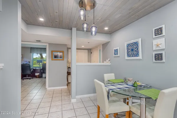 a living room with stainless steel appliances furniture and a view of kitchen