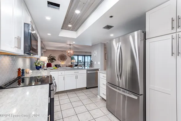 a kitchen with stainless steel appliances a stove a sink cabinets and a window