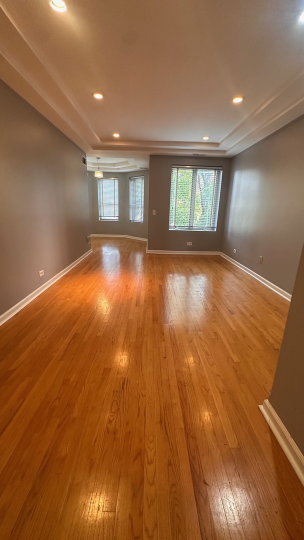 6714 South Chappel Avenue, Unit 2 Chicago, IL 60649 - Photo 1 of 10 an empty room with wooden floor and windows