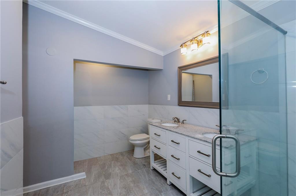 1277 Goodwin Road Northeast, Unit 1275 Atlanta, GA 30324 - Photo 12 of 19 a bathroom with a granite countertop sink and a mirror