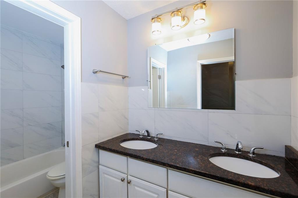1277 Goodwin Road Northeast, Unit 1275 Atlanta, GA 30324 - Photo 14 of 19 a bathroom with a granite countertop sink and a mirror