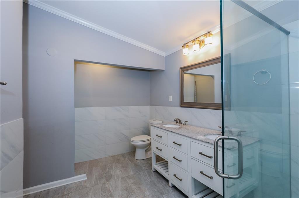 1277 Goodwin Road Northeast, Unit 1275 Atlanta, GA 30324 - Photo 15 of 19 a bathroom with a granite countertop sink and a mirror