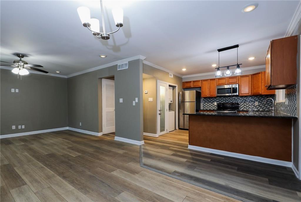 1277 Goodwin Road Northeast, Unit 1275 Atlanta, GA 30324 - Photo 3 of 19 a view of an empty room and kitchen with wooden floor