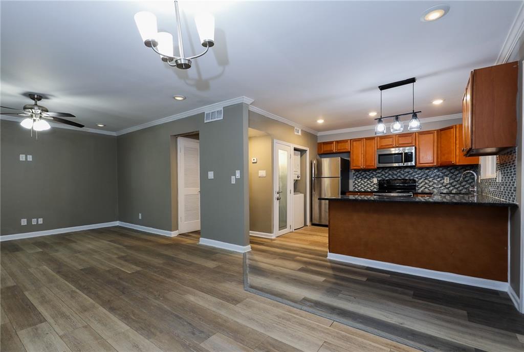 1277 Goodwin Road Northeast, Unit 1275 Atlanta, GA 30324 - Photo 6 of 19 a view of an empty room and kitchen with wooden floor