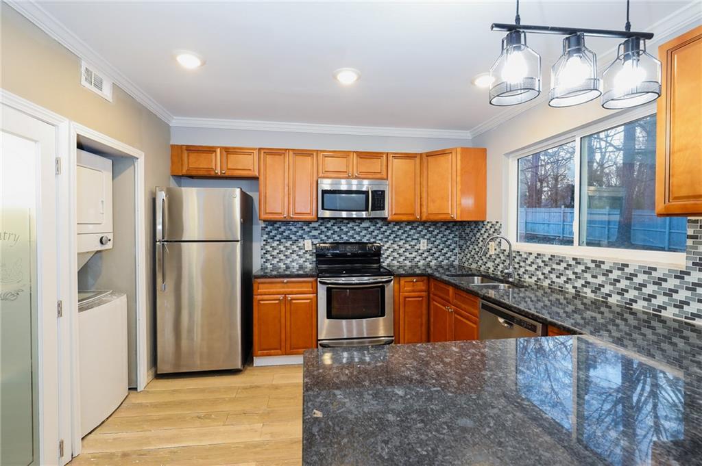1277 Goodwin Road Northeast, Unit 1275 Atlanta, GA 30324 - Photo 7 of 19 a kitchen with stainless steel appliances granite countertop a refrigerator and a sink