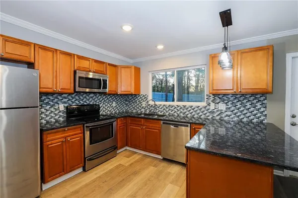 a kitchen with stainless steel appliances granite countertop a sink stove and refrigerator