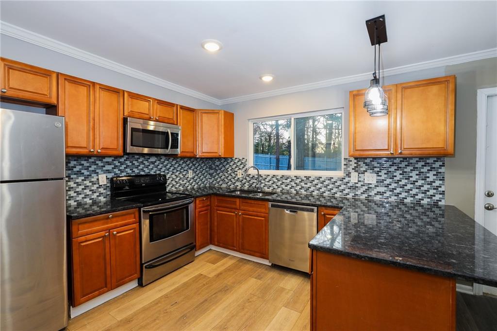 1277 Goodwin Road Northeast, Unit 1275 Atlanta, GA 30324 - Photo 8 of 19 a kitchen with stainless steel appliances granite countertop a sink stove and refrigerator
