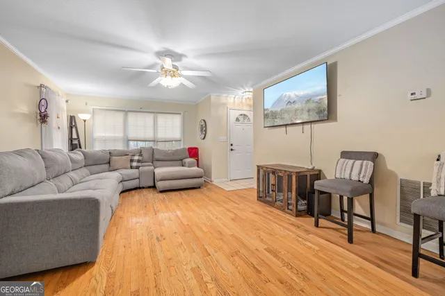 a living room with furniture and a wooden floor