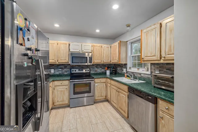 a kitchen with stainless steel appliances granite countertop a stove a sink and a refrigerator
