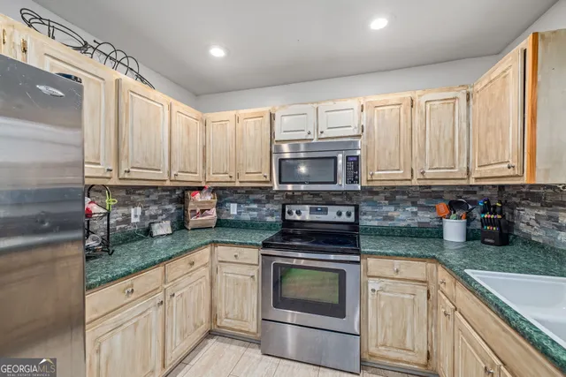 a kitchen with granite countertop white cabinets and stainless steel appliances