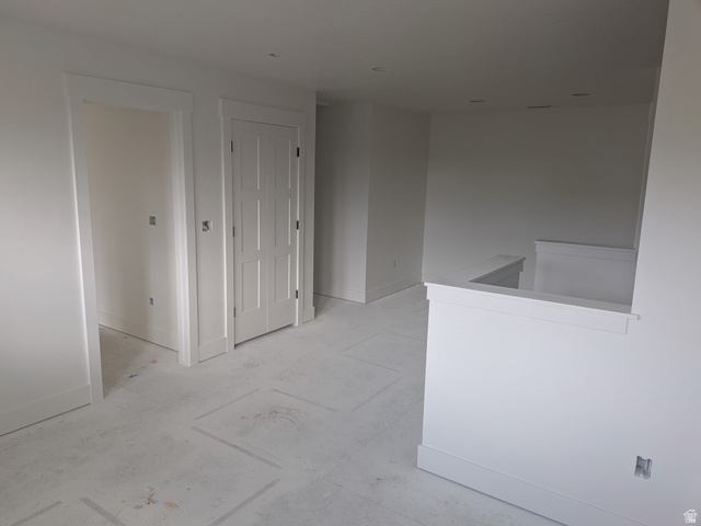 2771 West Aurora Avenue Mapleton, UT 84664 - Photo 22 of 39 Unfinished interior space featuring a paneled bifold door, white trim, recessed lighting, and a partial wall with cap molding