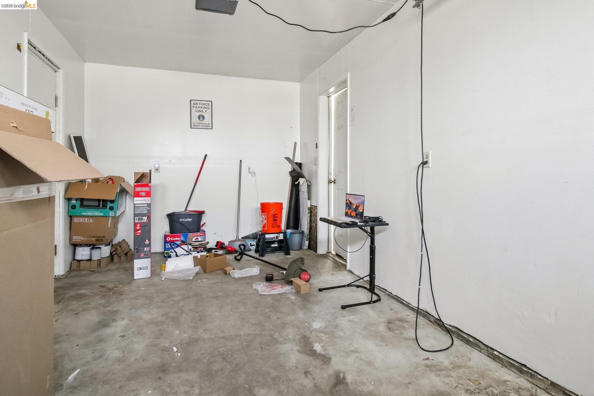 874 Pine Street Oakland, CA 94607 - Photo 24 of 39 Spacious garage featuring a concrete floor, painted walls, overhead lighting, and an access door