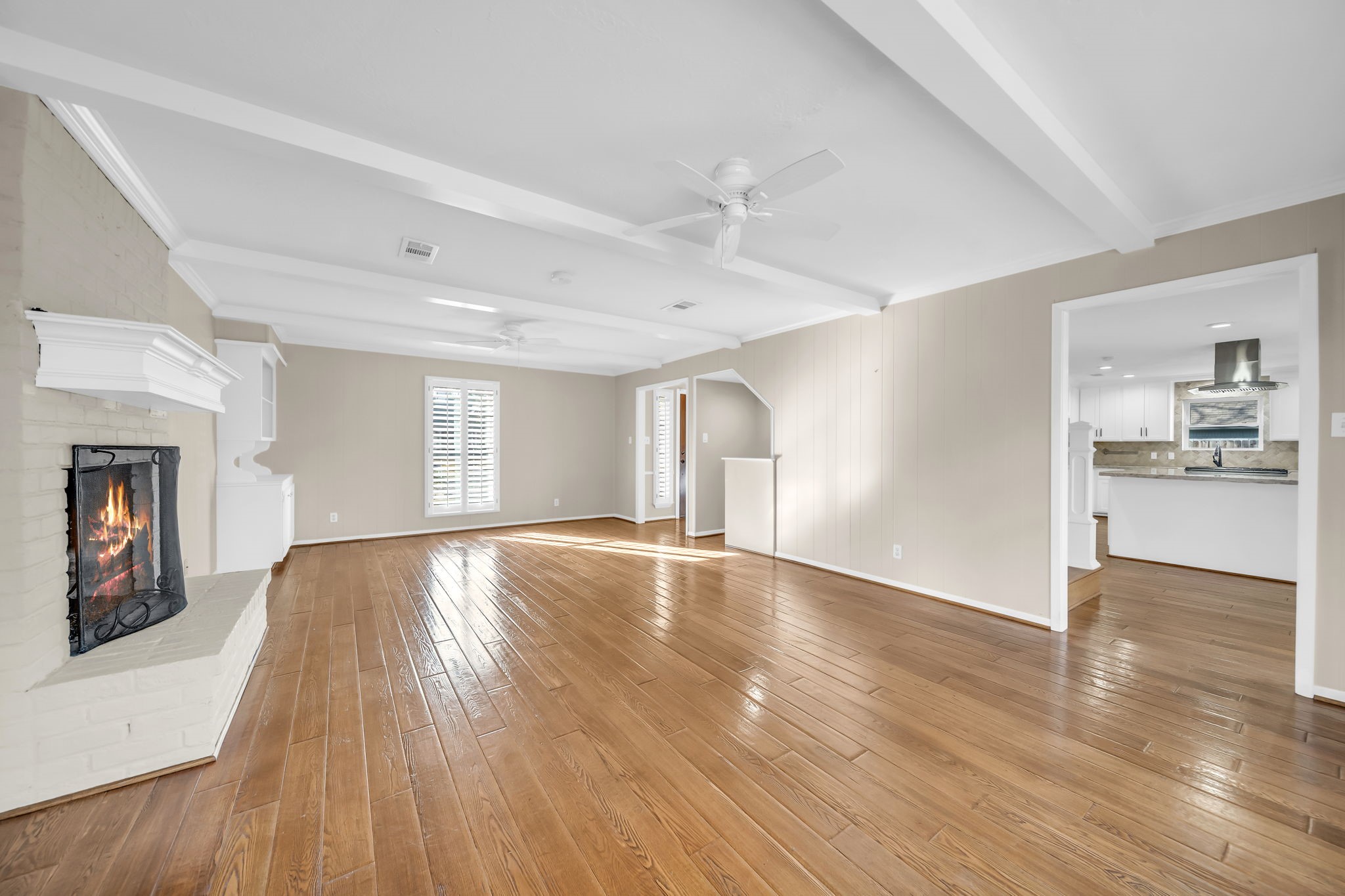 115 Heather Lane Conroe, TX 77385 - Photo 3 of 28 a view of empty room with wooden floor and a kitchen