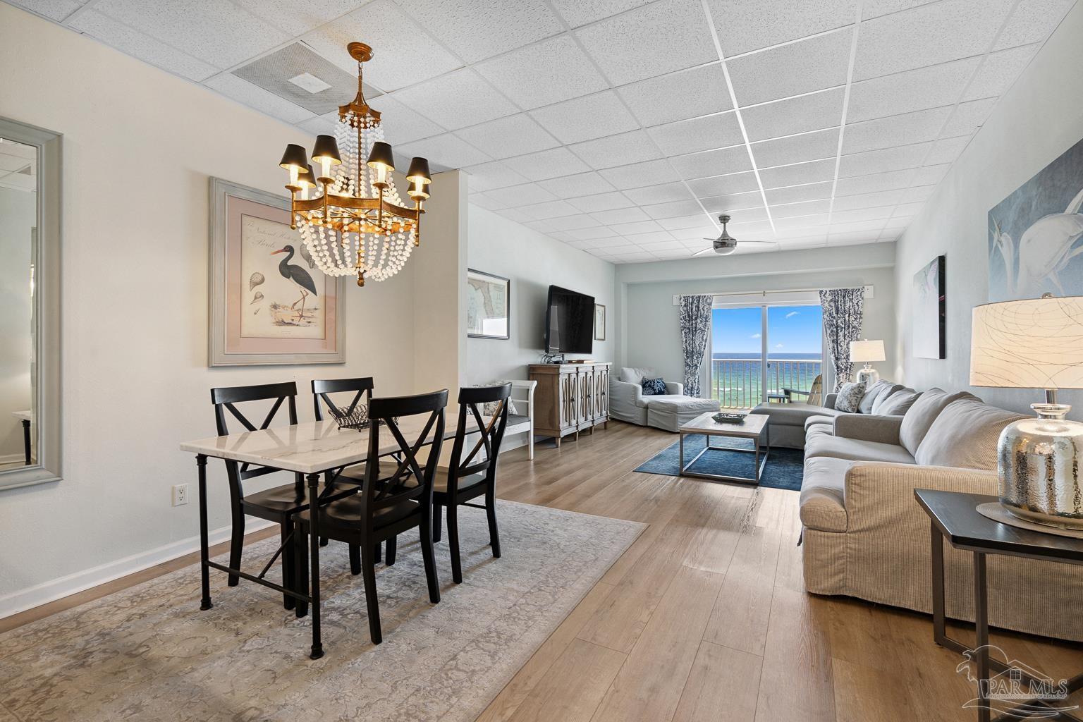 999 Fort Pickens Road, Unit 204 Pensacola Beach, FL 32561 - Photo 1 of 48 a view of a dining room with furniture wooden floor and chandelier