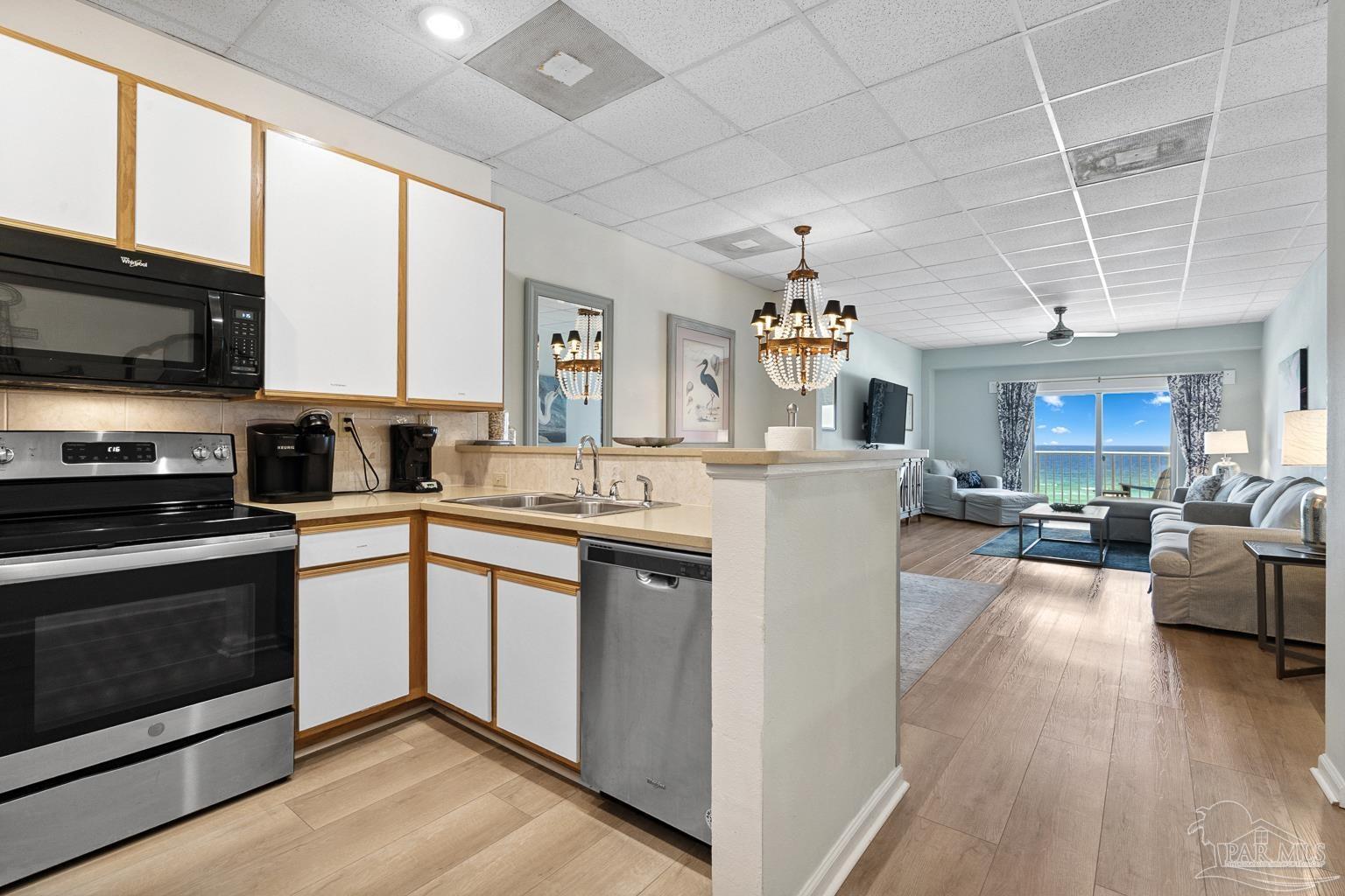 999 Fort Pickens Road, Unit 204 Pensacola Beach, FL 32561 - Photo 16 of 48 a kitchen with a sink stove and wooden cabinets