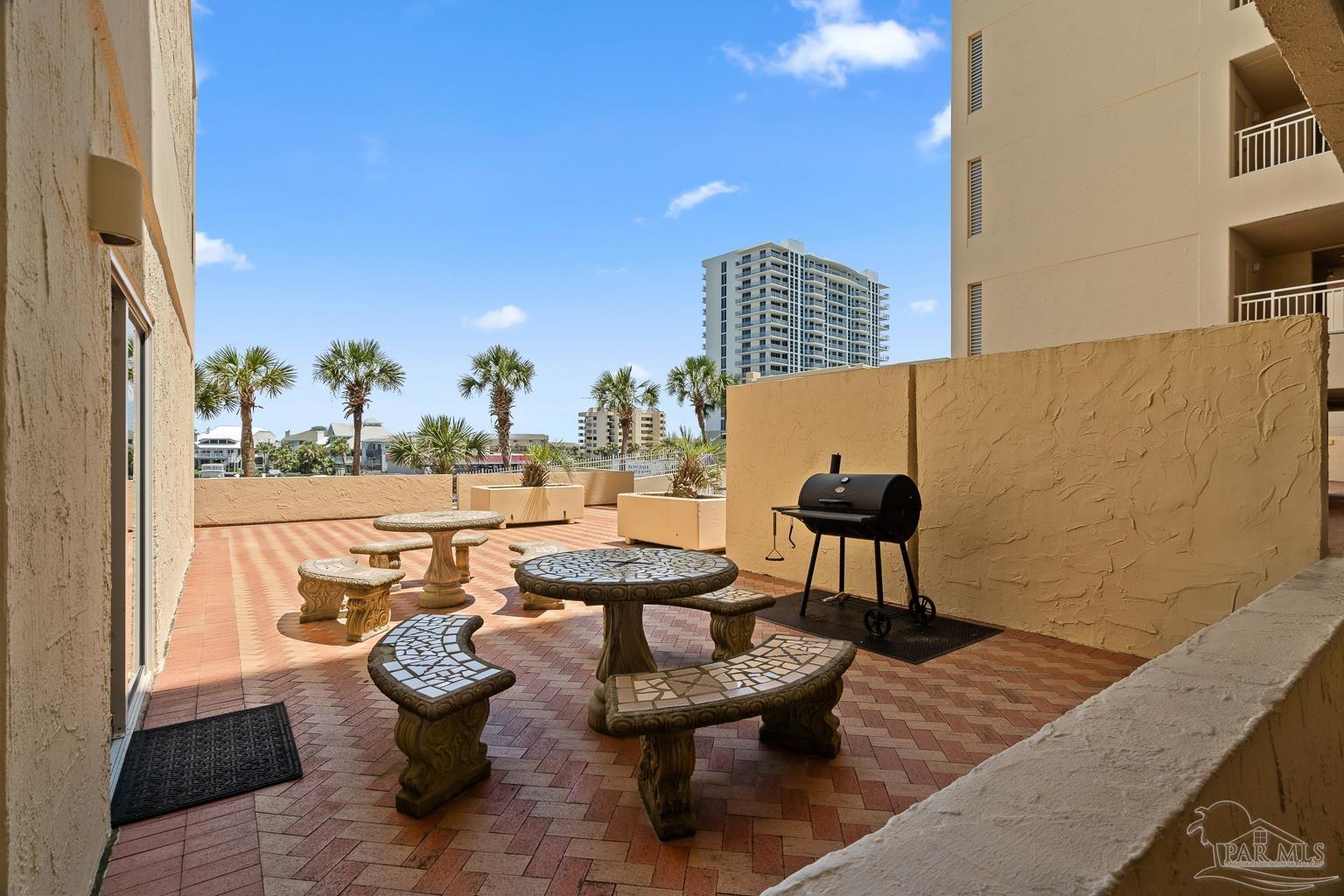 999 Fort Pickens Road, Unit 204 Pensacola Beach, FL 32561 - Photo 34 of 48 a outdoor sitting area with couch and a table
