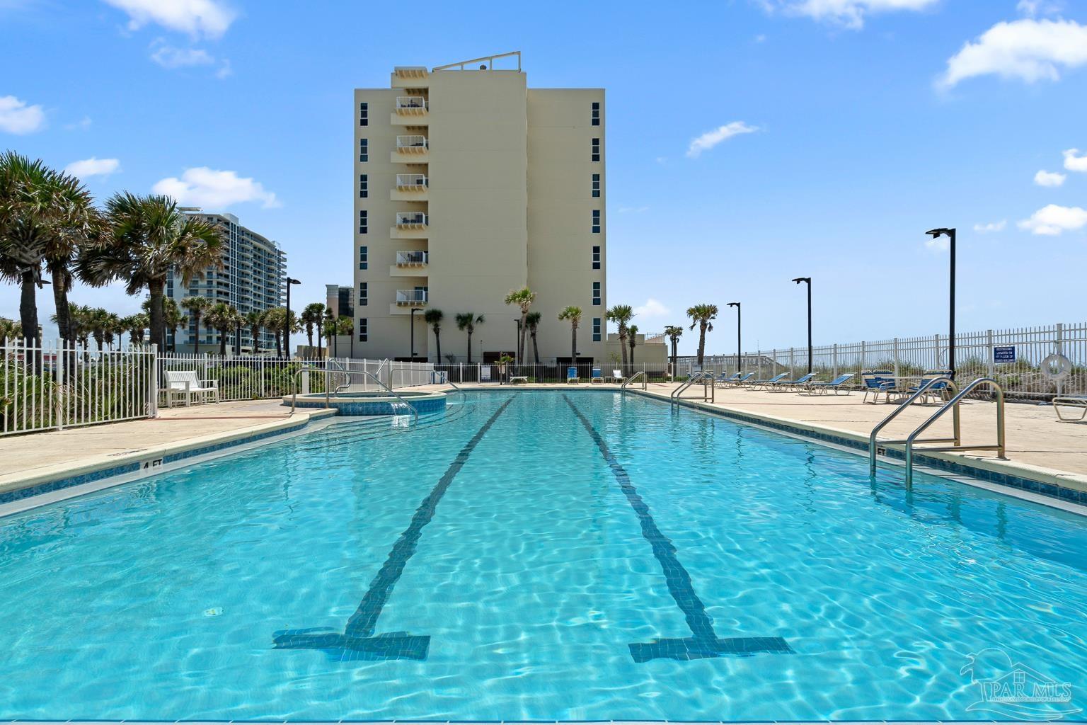 999 Fort Pickens Road, Unit 204 Pensacola Beach, FL 32561 - Photo 40 of 48 a view of a swimming pool with a lawn chairs