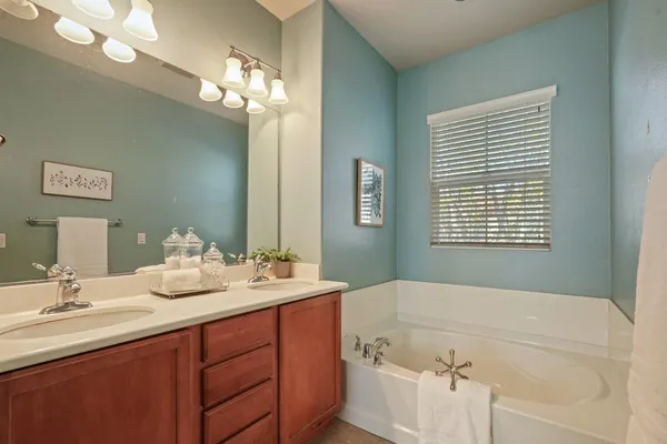 a bathroom with a tub sink and mirror