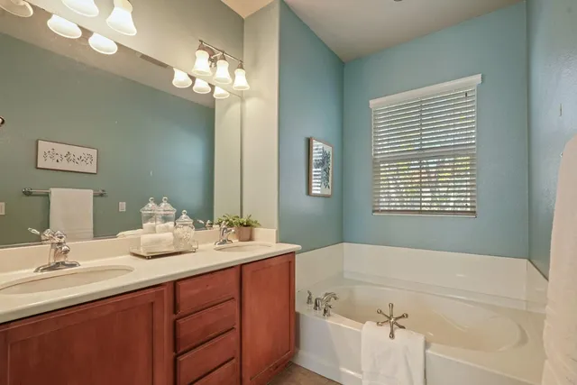 a bathroom with a tub sink and mirror