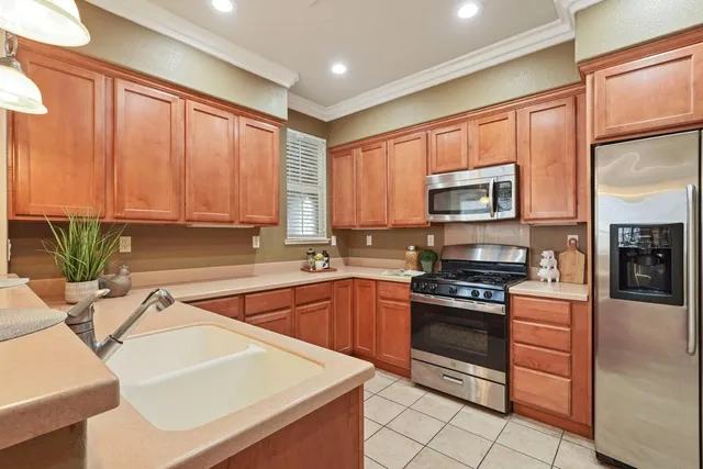 a kitchen with stainless steel appliances granite countertop a sink a stove and cabinets