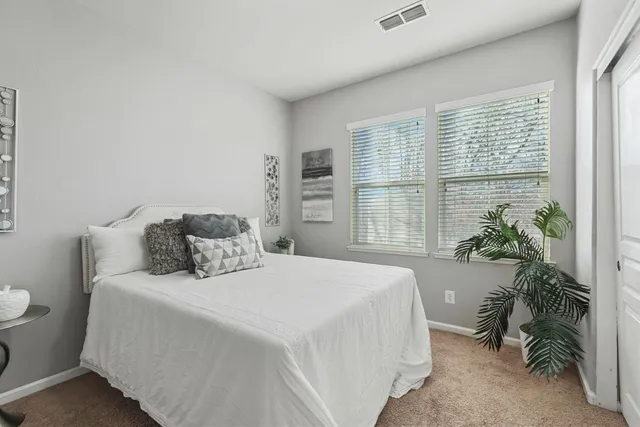 a bedroom with a bed and a large window