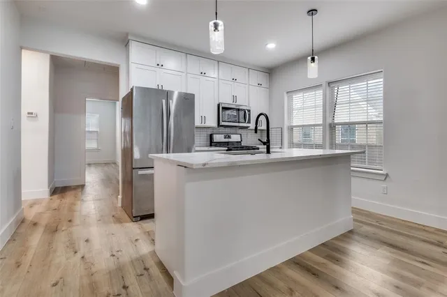 a kitchen with stainless steel appliances a refrigerator sink and microwave
