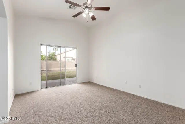 a view of a room with a ceiling fan and window