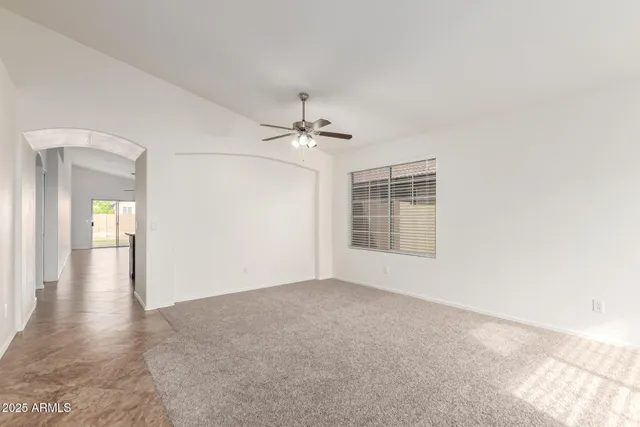 a view of a big room with windows and chandelier fan