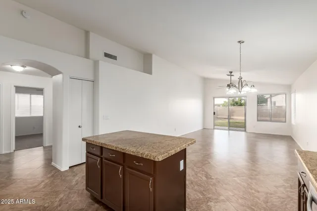 a view of a kitchen island a chandelier and wooden floor