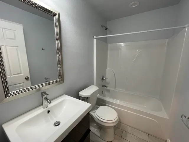 a bathroom with a sink mirror toilet and bathtub