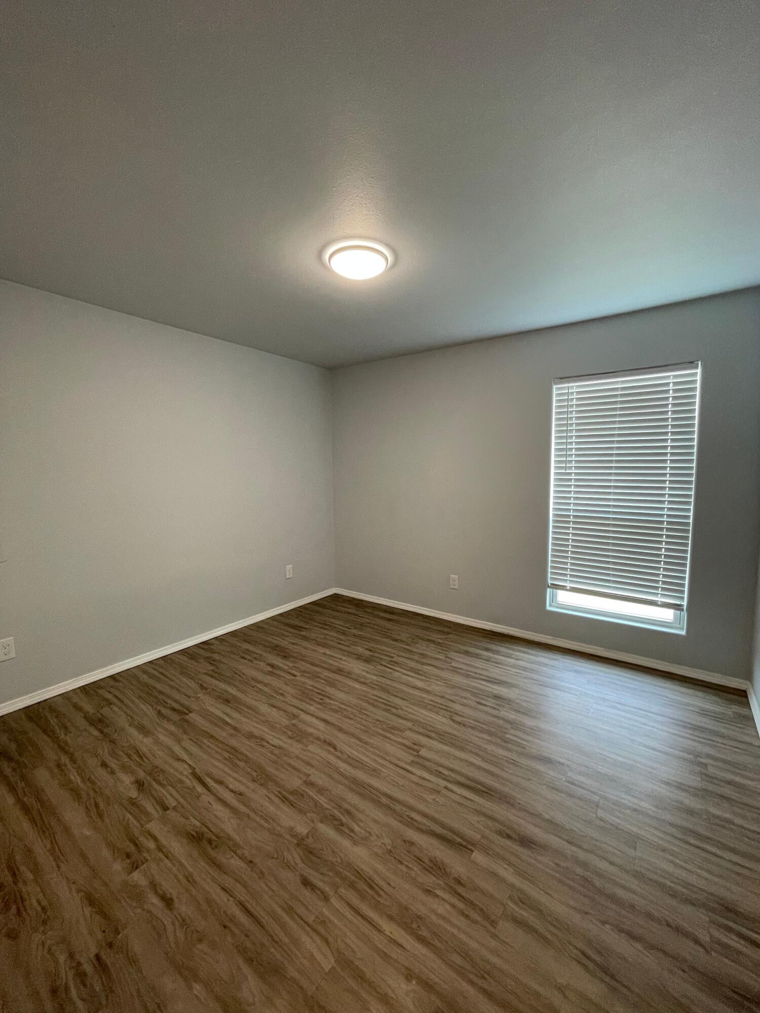 8410 11th Street Lubbock, TX 79416 - Photo 12 of 13 an empty room with wooden floor and windows