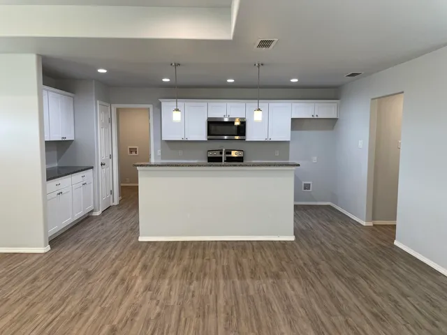 a kitchen with a sink and wooden floor