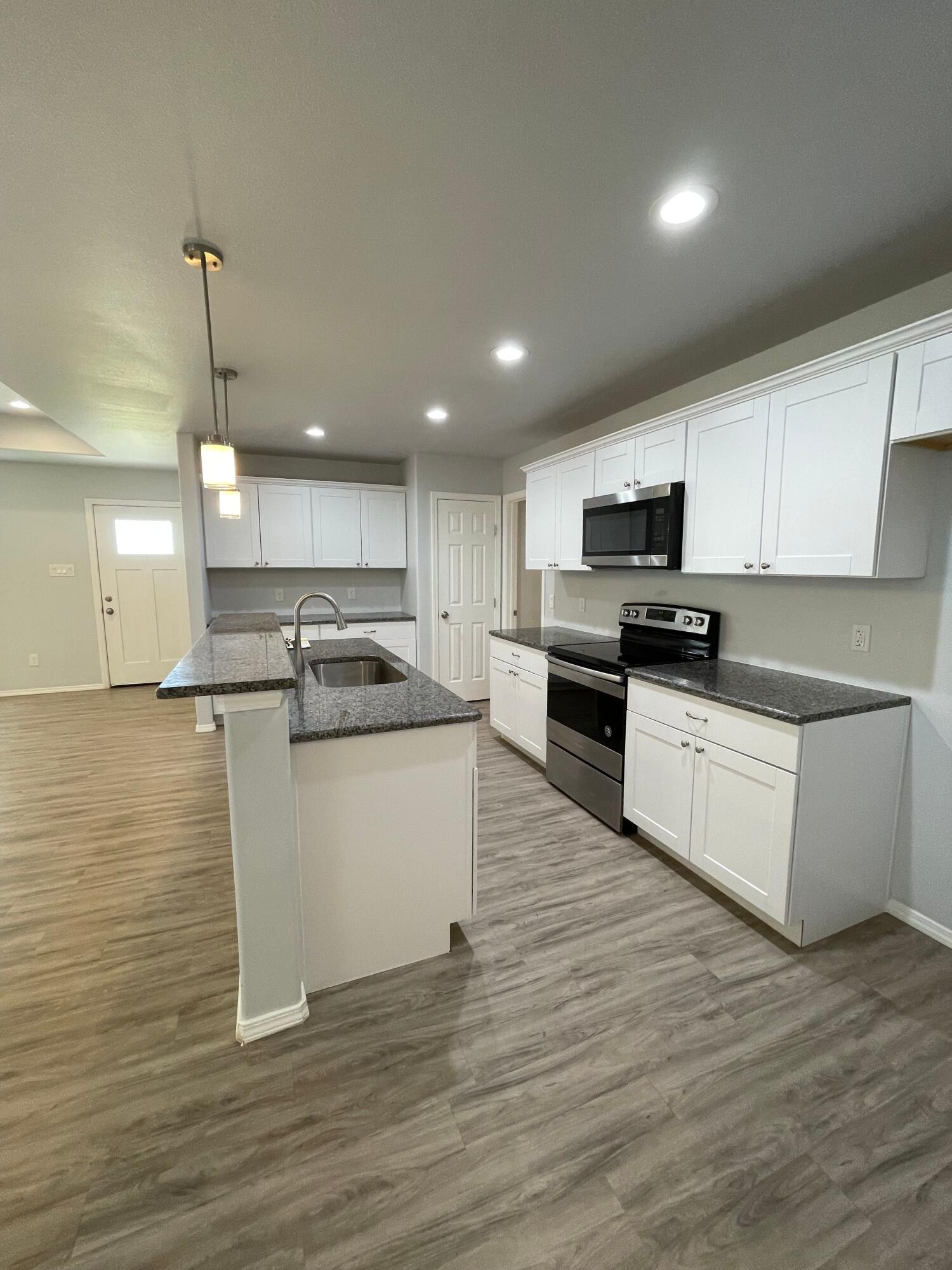 8410 11th Street Lubbock, TX 79416 - Photo 6 of 13 a kitchen with a refrigerator and a stove top oven