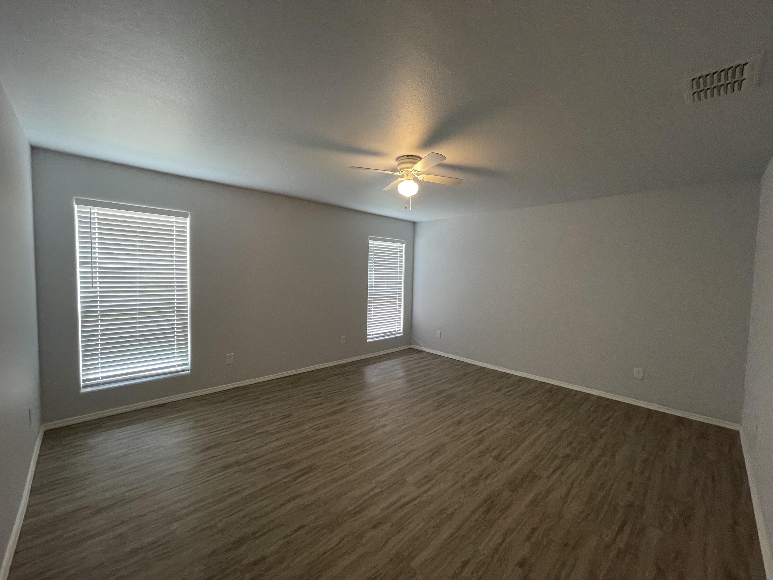 8410 11th Street Lubbock, TX 79416 - Photo 7 of 13 an empty room with wooden floor and windows