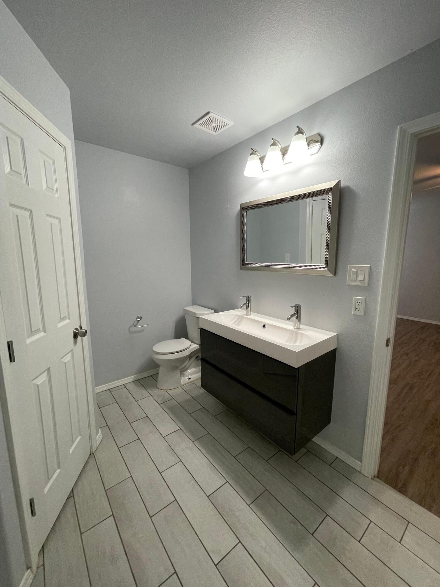 8410 11th Street Lubbock, TX 79416 - Photo 9 of 13 a bathroom with a sink and a mirror
