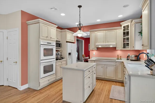 a kitchen with white cabinets and white appliances