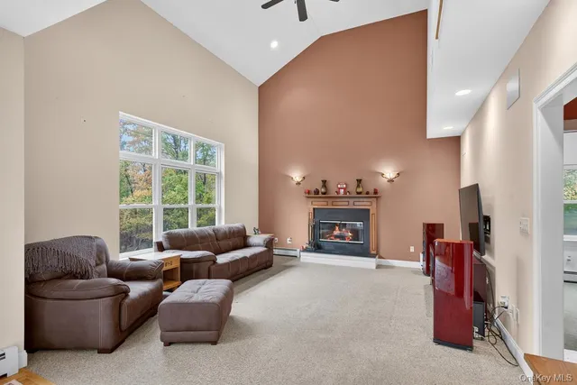 a living room with furniture a fireplace and a large window