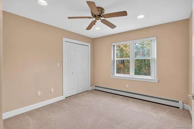 an empty room with a window and a fan
