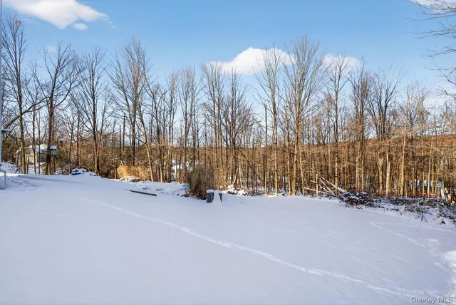 a view of tall trees with wooden fence