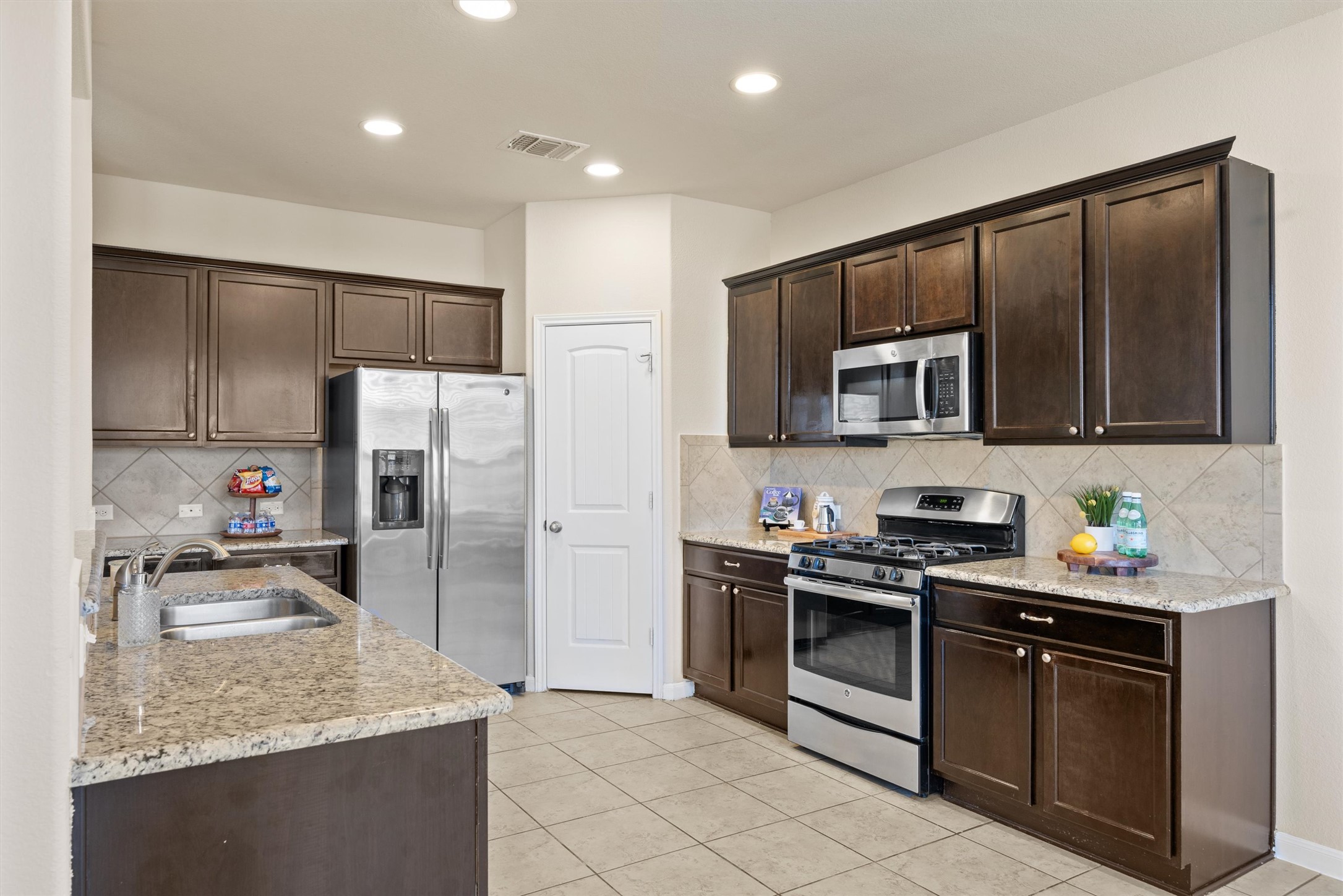 18120 Moreto Loop Pflugerville, TX 78660 - Photo 3 of 29 a kitchen with stainless steel appliances granite countertop a stove a sink and a refrigerator