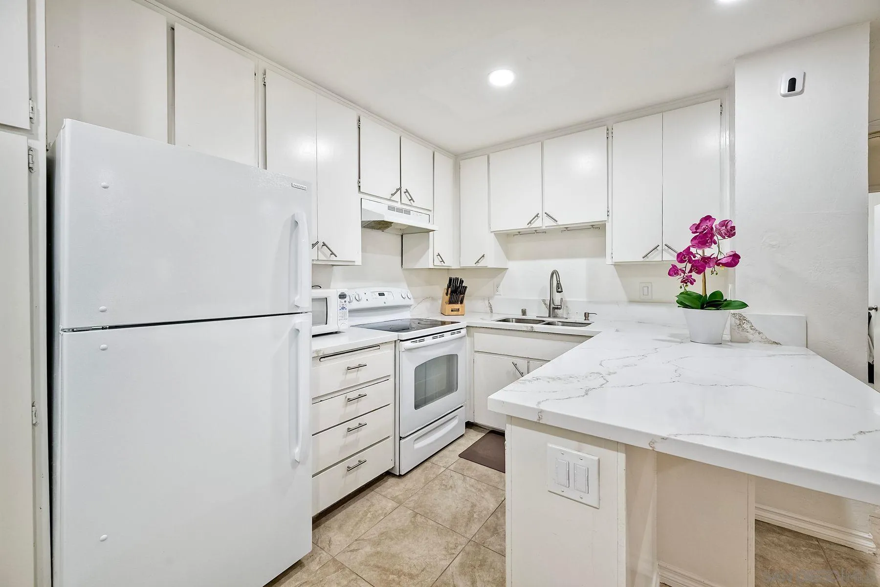 6358 Rancho Mission Road, Unit 623 San Diego, CA 92108 - Photo 6 of 21 a kitchen with granite countertop white cabinets and white appliances