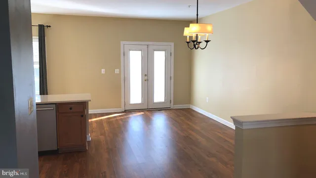 a hallway with front door wooden floor and windows