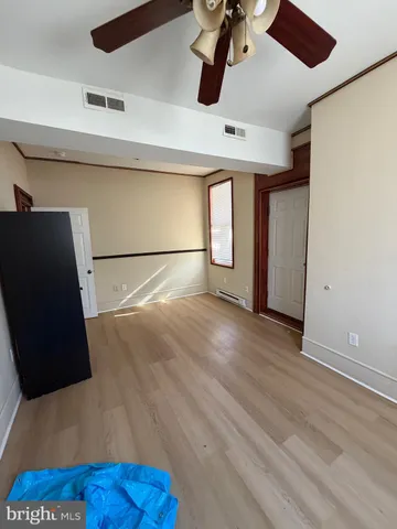 a view of empty room with wooden floor